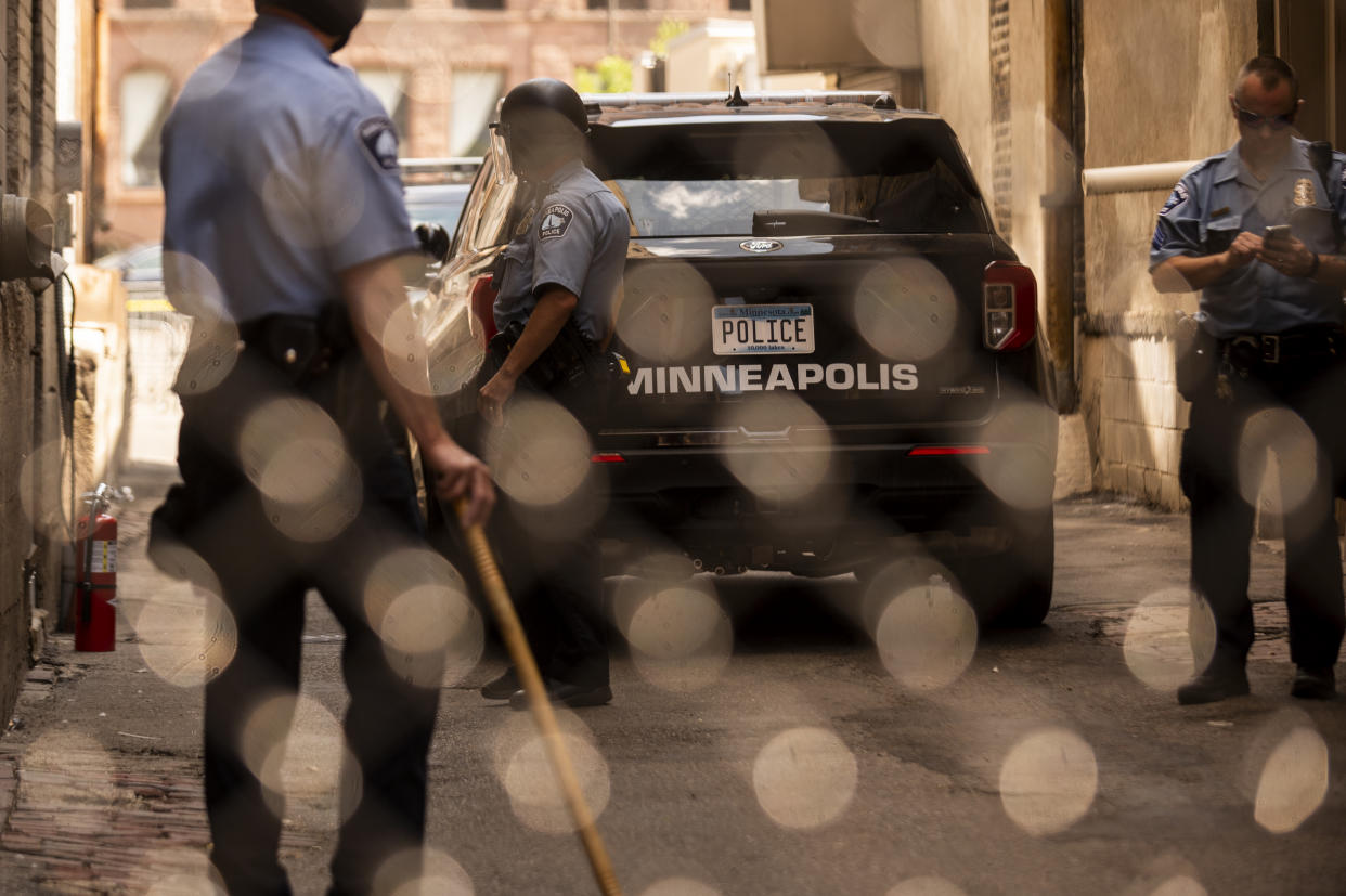 Members of the Minneapolis Police Department seen through a chain link gate on June 13, 2020.