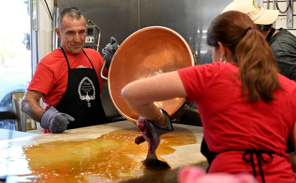 Peter Vrinios and his wife Tamela Behm-Vrinios pour out the liquid candy which will be made into candy canes atop his family’s antique candy table at the Fudge Factory in Bradenton Beach. Vrinios’ family has been making candy for four generations and has been putting on a candy show during the holidays. Tiffany Tompkins/ttompkins@bradenton.com