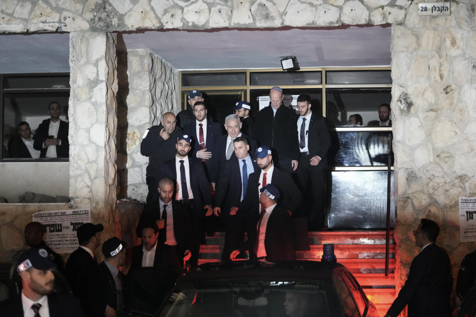 Israeli Prime Minister Benjamin Netanyahu, center, walks out of the home of his ally Aryeh Deri, a Cabinet minister and the head of the ultra-Orthodox Shas party, In Jerusalem, Wednesday, Jan. 18, 2023. Israel's Supreme Court ruled Wednesday that Netanyahu must fire Deri, presenting the Israeli leader with a potential coalition crisis and deepening a rift over the power of the courts. The high court ruled that Deri is disqualified from serving as a minister after he was convicted last year for tax offenses and placed on probation as part of a plea deal. (AP Photo/Mahmoud Illean)