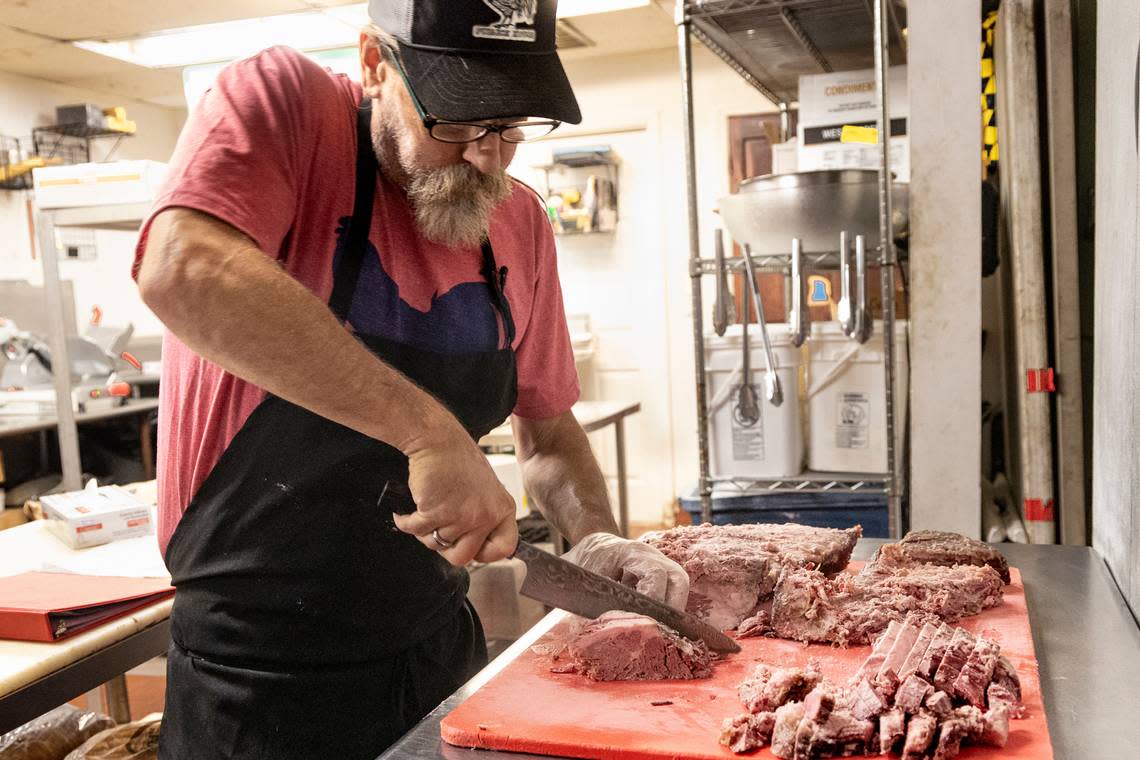 Drew Kalagher cuts thick slices of corned beef brisket. He makes his own corned beef at Publick House.