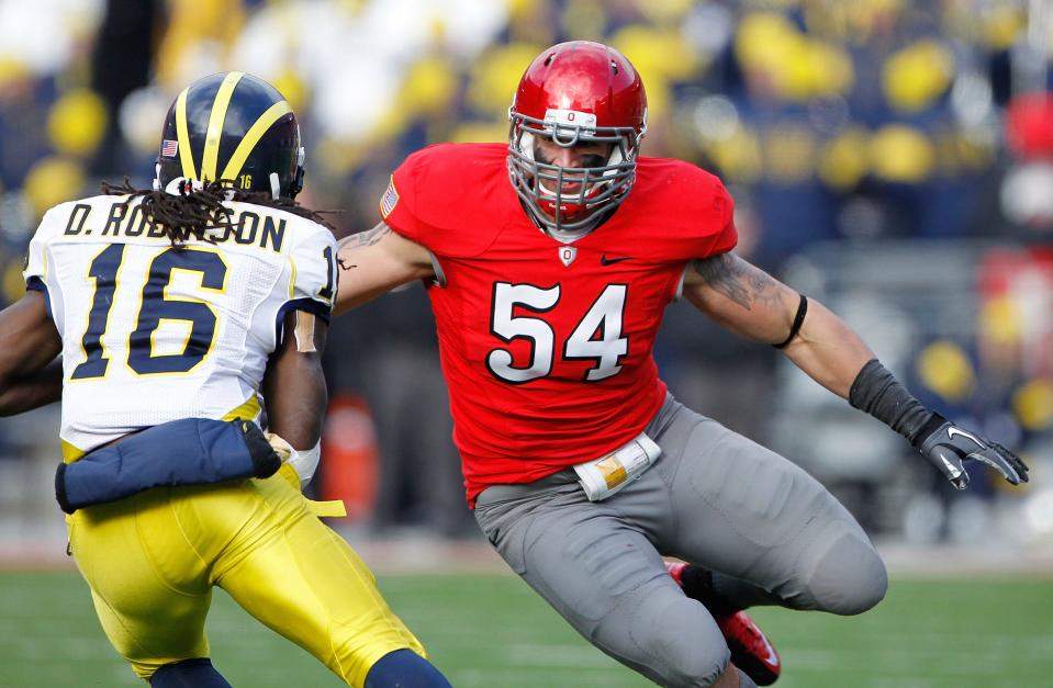 Ohio State Buckeyes defensive lineman John Simon (54) goes after Michigan Wolverines quarterback Denard Robinson (16) in the second half of their NCAA football game at the Ohio Stadium, Novemver 27, 2010. (Dispatch photo by Neal C. Lauron)