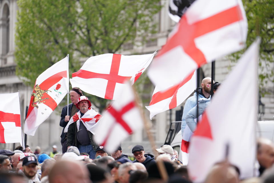 People wave flags during a St George's Day rally on Whitehall, in Westminster, central London. (PA)