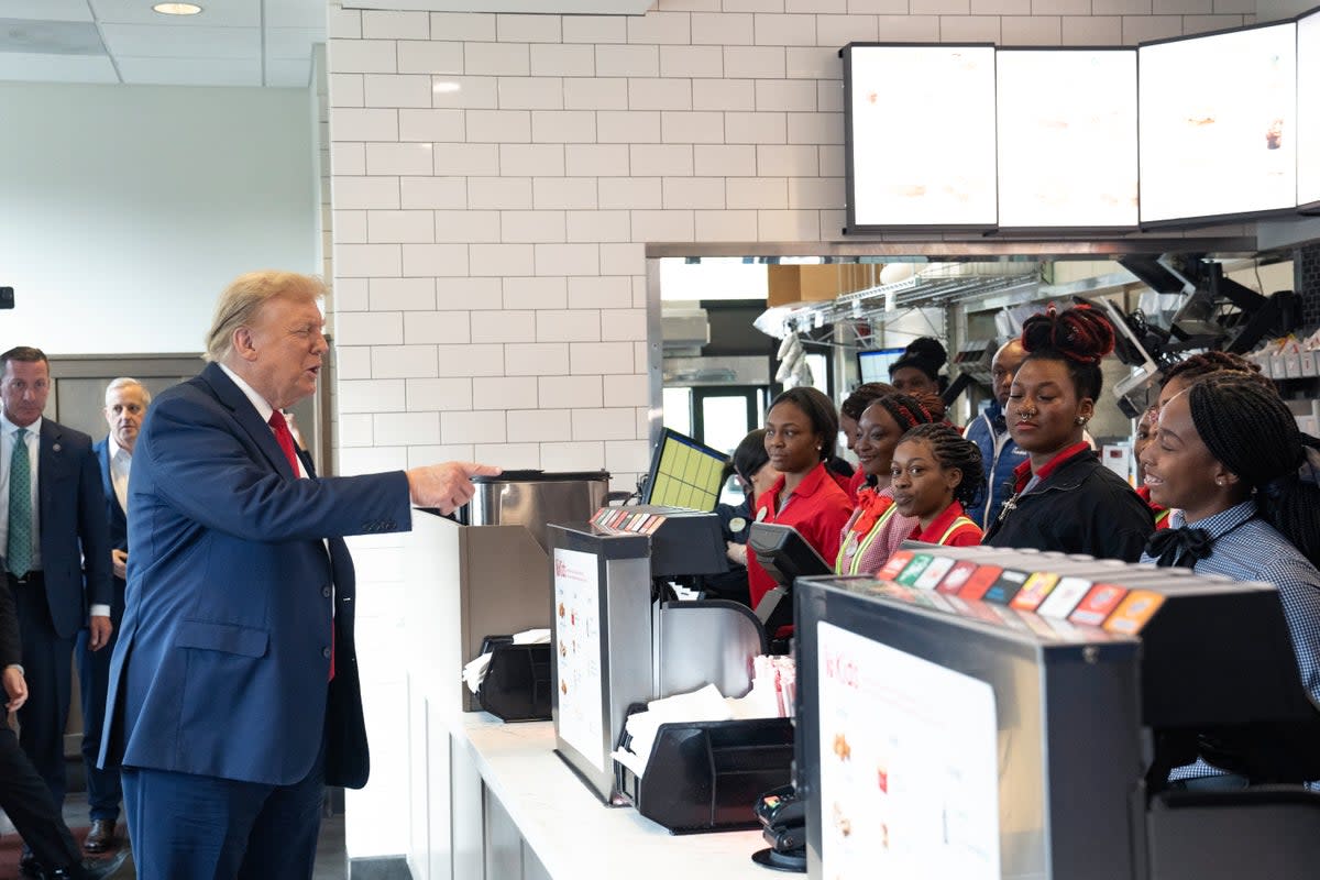 Trump indulges one of his hobbies – handing out fast food - as he hits a Chick-fil-A and buys lunch for fans (Getty Images)