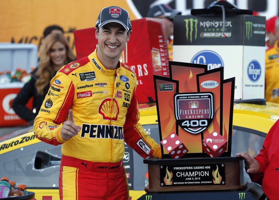 Joey Logano stands with the trophy after winning a NASCAR Cup Series auto race at Michigan International Speedway, Monday, June 10, 2019, in Brooklyn, Mich. (AP Photo/Carlos Osorio)