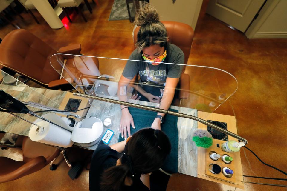 Getting a manicure through new plexiglass partitions in Harahan, Louisiana, on May 15, 2020.