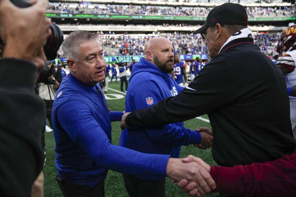 New York Giants head coach Brian Daboll, center, and Washington Commanders head coach Ron Rivera, right, meet on the field after an NFL football game, Sunday, Oct. 22, 2023, in East Rutherford, N.J. (AP Photo/Seth Wenig)