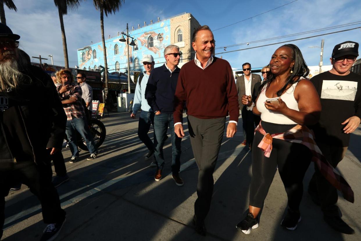 Rick Caruso hears the concerns of a Los Angeles resident while walking along Ocean Front Walk in Venice on Friday.