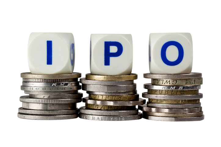 Three white blocks with letters IPO on them sitting atop small stacks of coins.