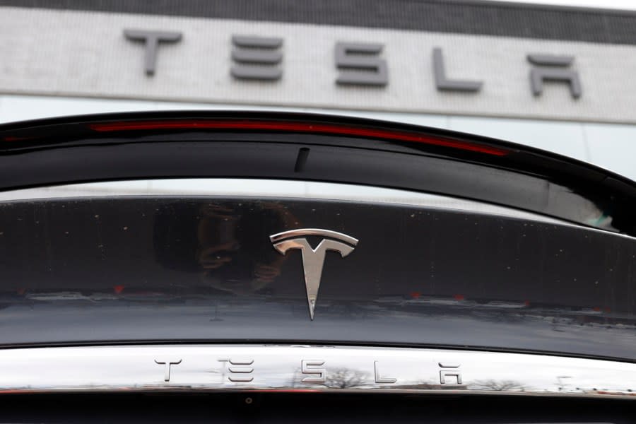 The Tesla company logo shines off the rear deck of an unsold 2020 Model X at a Tesla dealership, April 26, 2020. (AP Photo /David Zalubowski, File)