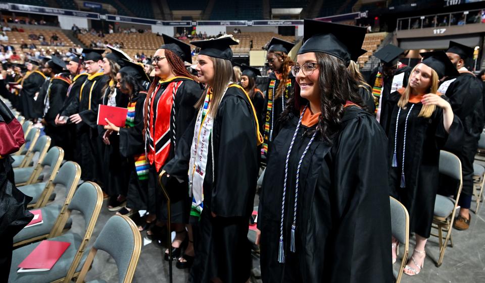 Lexi Albin of Auburn stands with the Class of 2023 to receive her diploma during Anna Maria College's 74th commencement exercises at the DCU Center Monday.