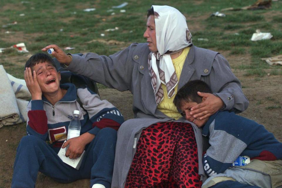 An ethnic Albanian woman consoles her two twin sons at the Morini, Albania, border after crossing on foot from Kosovo on May 25, 1999. Kosovar refugees continued to cross into neighboring Albania as NATO tried to relocate the over-crowded camps further south from the volatile border area.