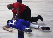 Philadelphia 76ers forward Tobias Harris (12) is attended to after hitting his head against the Boston Celtics during the third quarter of Game 4 of an NBA basketball first-round playoff series, Sunday, Aug. 23, 2020, in Lake Buena Vista, Fla. (Kim Klement/Pool Photo via AP)