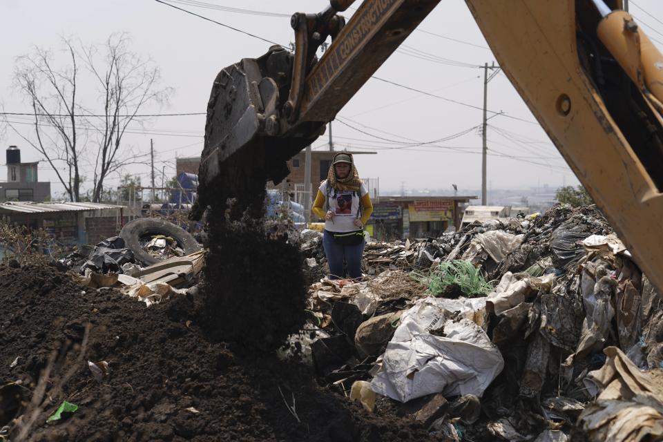 A relative stands by as a mechanical shovel removes earth from a clandestine grave during a search for missing loved ones, in Tepotzotlán, Mexico, Friday, April 19, 2024. Hundreds of collectives searching for missing loved ones fanned out across Mexico on Friday as part of a coordinated effort to raise the profile of efforts that are led by the families of the tens of thousands of missing across Mexico without support from the government. (AP Photo/Marco Ugarte)