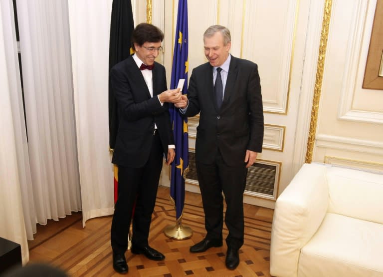 Outgoing Belgian Prime Minister Yves Leterme (R) hands over the keys of his office to newly appointed Prime Minister Elio Di Rupo (L) in Brussels on December 6, 2011