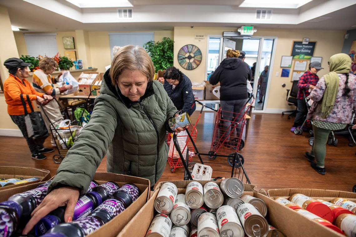 Arbor Creek Family Apartments resident Connie Casias gathers her share of groceries at a distribution by the Elk Grove Food Bank Services in November. The organization asks Book of Dreams readers for donations to resume mobile cooking classes for seniors.
