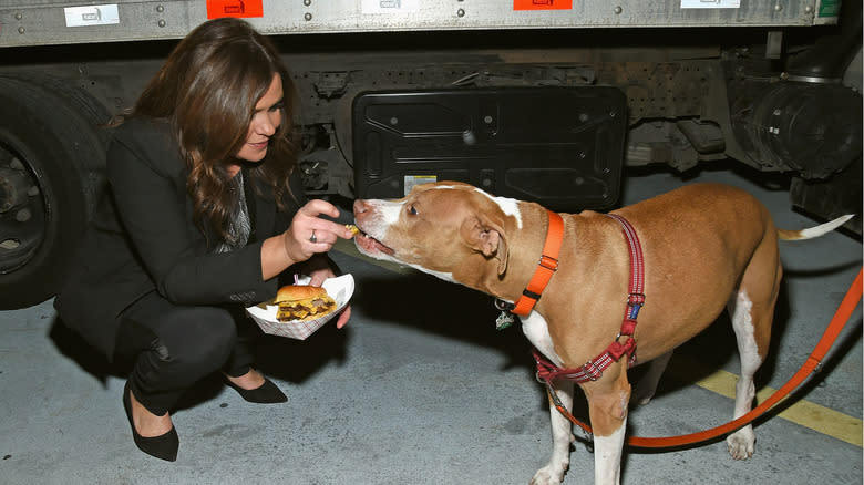 Rachael Ray feeding a dog a piece of a burger