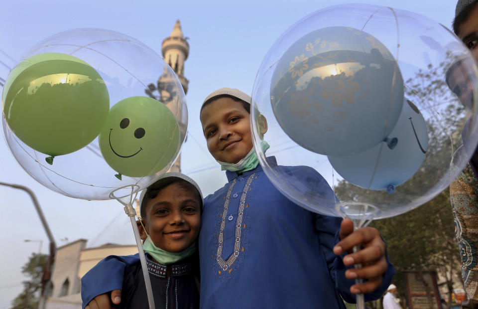 Muslim boys hold balloons after performing an Eid al-Fitr prayer at a mosque in Karachi, Pakistan, Thursday, May 13, 2021. Millions of Muslims across the world are marking a muted and gloomy holiday of Eid al-Fitr, the end of the fasting month of Ramadan - a usually joyous three-day celebration that has been significantly toned down as coronavirus cases soar. (AP Photo/Fareed Khan)