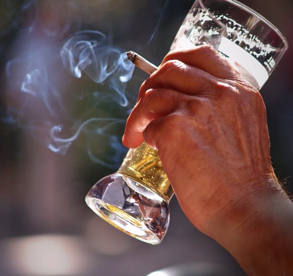 Man holding a beer and a cigarette