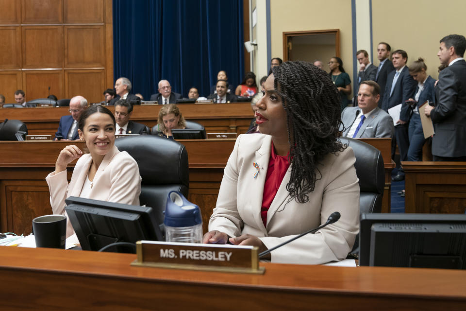 Rep. Ayanna Pressley, D-Mass., center, joined at left by Rep. Alexandria Ocasio-Cortez, D-N.Y., responds to the roll call as the House Oversight and Reform Committee votes 24-15 to hold Attorney General William Barr and Commerce Secretary Wilbur Ross in contempt for failing to turn over subpoenaed documents related to the Trump administration's decision to add a citizenship question to the 2020 census, on Capitol Hill in Washington, Wednesday, June 12, 2019. (AP Photo/J. Scott Applewhite)