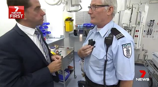 Security chief Graham Bushell shows Health Minister Cameron Dick how the simple cameras work. Source: 7 News