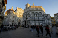 People walk past St. John's Baptistery, one of the oldest churches in Florence, central Italy, Tuesday, Feb. 7, 2023. The Baptistery's dome is undergoing a restoration work that will be done from an innovative scaffolding shaped like a giant mushroom that will stand for the next six years in the center of the church, and that will be open to visitors allowing them for the first and perhaps only time, to come come face to face with more than 1,000 square meters of precious mosaics covering the dome. (AP Photo/Andrew Medichini)