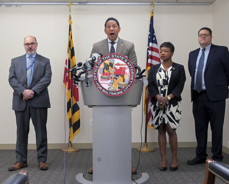 From left, Ernest Reitz, assistant state attorney, Angela Galeano, chief of staff and Steve Trostle chief of public trust and police integrity flank Ivan Bates, Baltimore City State's Attorney who announces separate indictments on two different officers with Baltimore Police Thursday May 4, 2023. Two Baltimore police officers were indicted this week in separate cases, including an 11-year department veteran accused of selling drugs on the clock — allegations that come as the agency seeks to rebuild its reputation after the Gun Trace Task Force corruption scandal ruptured public trust. (Karl Merton Ferron/The Baltimore Sun via AP)