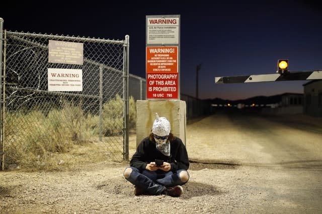 A man in a tinfoil hat sits near an entrance to the Nevada Test and Training Range near Area 51