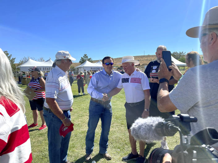 Republican Nevada Senate candidate Adam Laxalt, center left, takes pictures with supporters at the seventh annual Basque Fry at the Corley Ranch on Saturday, Aug. 13, 2022, outside Gardnerville, Nev. (AP Photo/Gabe Stern)