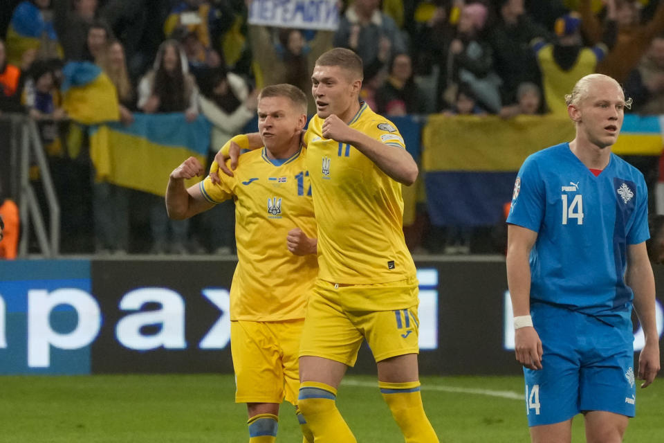 Oleksandr Zinchenko (izquierda) y Arem Dovbyk, de Ucrania, festejan el triunfo sobre Islandia en el repechaje hacia la Eurocopa, el martes 26 de marzo de 2024, en Breslavia, Polonia (AP Foto/Czarek Sokolowski)