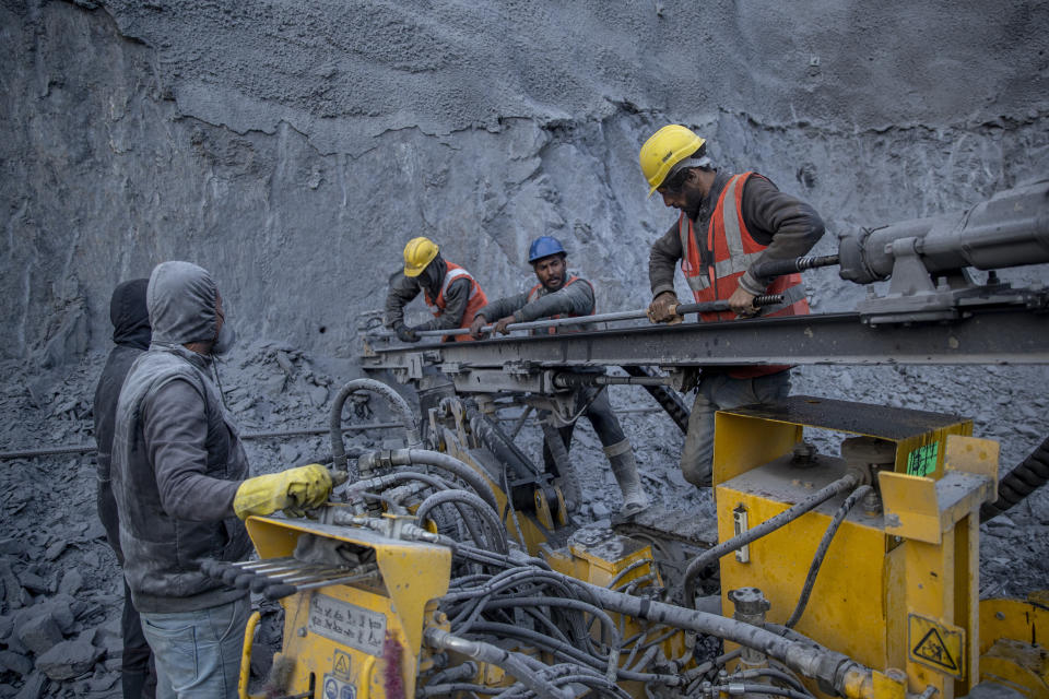 Nikhil Kumar, center, wearing blue helmet, helps other workers to fix an iron road as they prepare a machine for rock bolting at the entrance of Nilgrar Tunnel in Baltal area northeast of Srinagar, Indian controlled Kashmir, Tuesday, Sept. 28, 2021. High in a rocky Himalayan mountain range, hundreds of people are working on an ambitious project to drill tunnels and construct bridges to connect the Kashmir Valley with Ladakh, a cold-desert region isolated half the year because of massive snowfall. The $932 million project’s last tunnel, about 14 kilometers (9 miles) long, will bypass the challenging Zojila pass and connect Sonamarg with Ladakh. Officials say it will be India’s longest and highest tunnel at 11,500 feet (3,485 meters). (AP Photo/Dar Yasin)