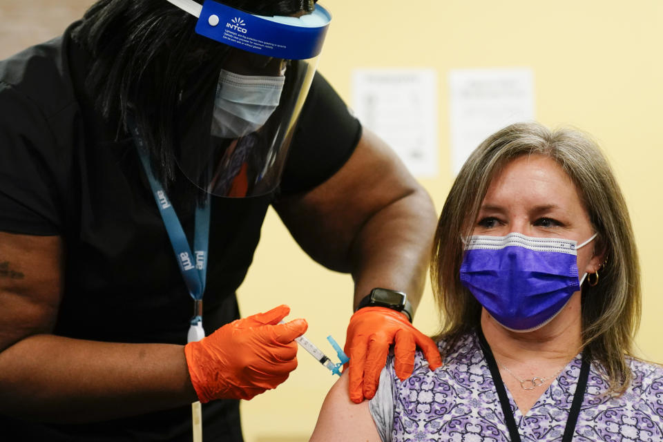 FILE - In this March 15, 2021, file photo, Nurse Monique Bourgeois, left, administers the Johnson & Johnson COVID-19 vaccine to educator Diane Kay at a vaccination site setup for teachers and school staff at the Berks County Intermediate Unit in Reading, Pa. Optimism is spreading in the U.S. as COVID-19 deaths plummet and states ease restrictions and open vaccinations to younger adults. But across Europe, dread is setting in with another wave of infections that is closing schools and cafes and bringing new lockdowns. (AP Photo/Matt Rourke, File)