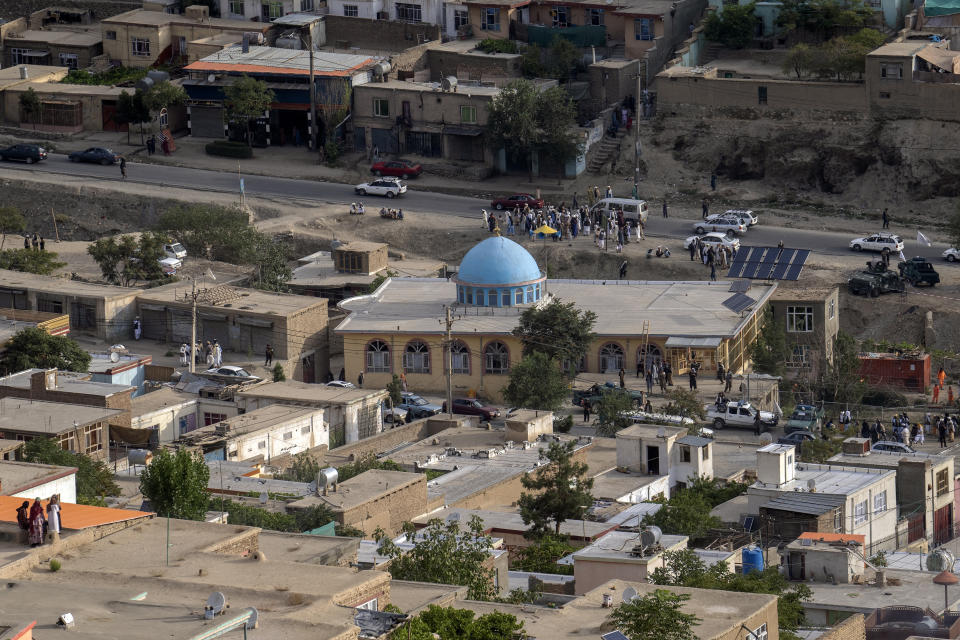 Taliban fighters and local residents gather around a mosque that has been bombed, in Kabul, Afghanistan, Thursday, Aug. 18. 2022. A bombing at a mosque in Kabul during evening prayers on Wednesday killed at least 10 people, including a prominent cleric, and wounded over two dozen, an eyewitness and police said. (AP Photo/Ebrahim Noroozi)