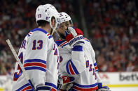 New York Rangers' Vincent Trocheck, right, talks with teammate Alexis Lafrenière (13) before a face off against the Carolina Hurricanes during the third period in Game 4 of an NHL hockey Stanley Cup second-round playoff series in Raleigh, N.C., Saturday, May 11, 2024. (AP Photo/Karl B DeBlaker)