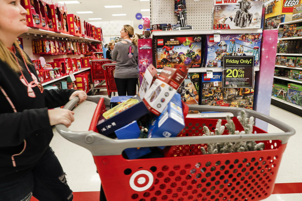 FILE- In this Nov. 23, 2018, file photo shoppers browse the aisles during a Black Friday sale at a Target store in Newport, Ky. Strong online sales, traffic growth in newly remodeled stores and expanded delivery options pushed Target beyond most expectations in the crucial fourth quarter, when retailers ring up holiday sales. Target reported financial results on Tuesday, March 5, 2019. (AP Photo/John Minchillo, File)