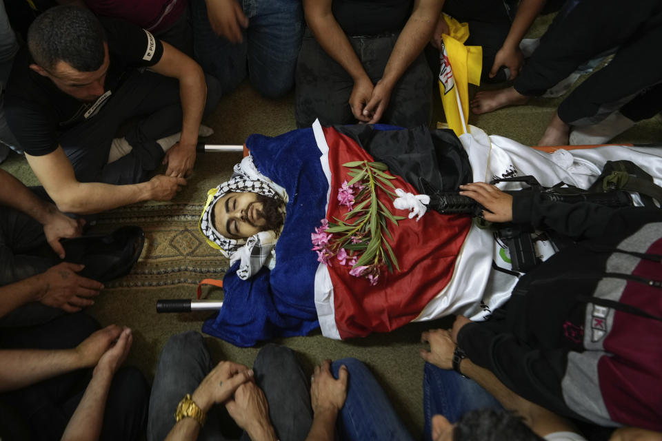 Palestinian mourners gather around the body of Bilal Kabaha during his funeral in the West Bank village of Yabed, Thursday, June 2, 2022. Kabaha was killed during clashes with Israeli forces when they entered Yabed to demolish the family home of a slain Palestinian attacker who had gunned down five people in the Israeli city of Bnei Brak in March. (AP Photo/Majdi Mohammed)