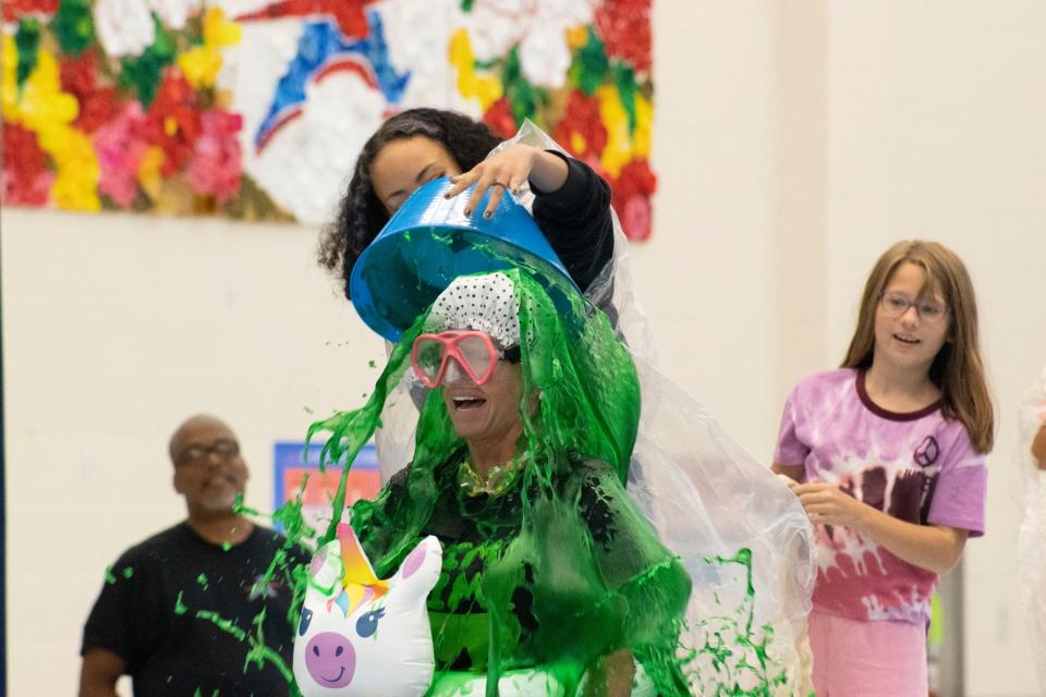 Alliance Intermediate School Superintendent Stephanie Garren takes a dose of green slime over the head during the school's "Slime Time" event on Friday, Sept. 8, 2023. Students purchased raffle tickets during the week for the chance to drop the slime on the school's staff. Funds raised will go to the monthly PBIS incentives.
