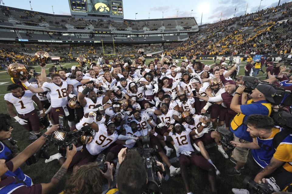 Minnesota celebrates on the field after their 12-10 win over Iowa in a NCAA college football game, Saturday, Oct. 21, 2023, in Iowa City, Iowa. (AP Photo/Matthew Putney)