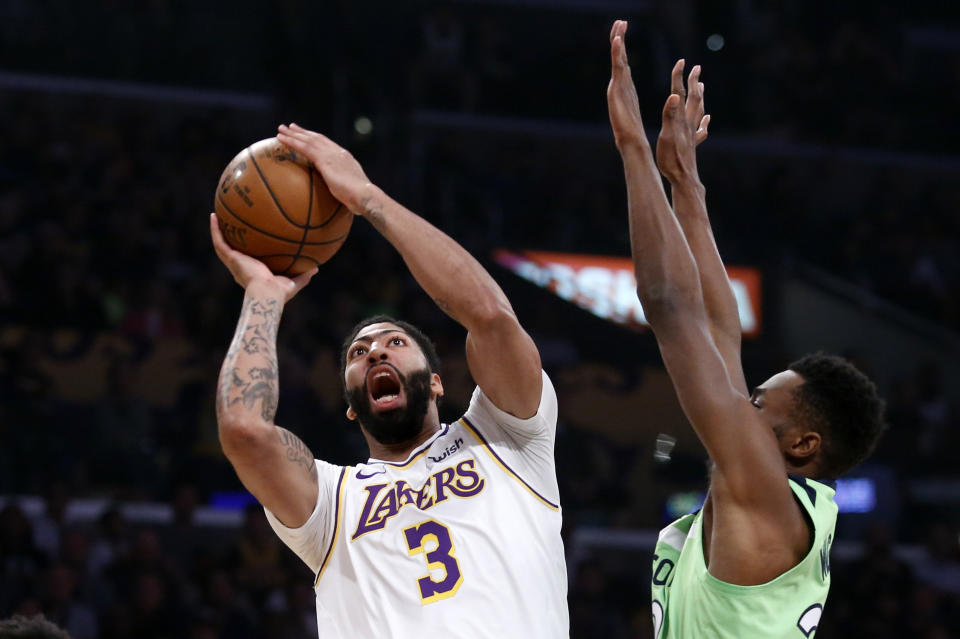 Los Angeles Lakers' Anthony Davis (3) shoots under pressure from Minnesota Timberwolves' Andrew Wiggins (22) during the first half of an NBA basketball game, Sunday, Dec. 8, 2019, in Los Angeles. (AP Photo/Ringo H.W. Chiu)