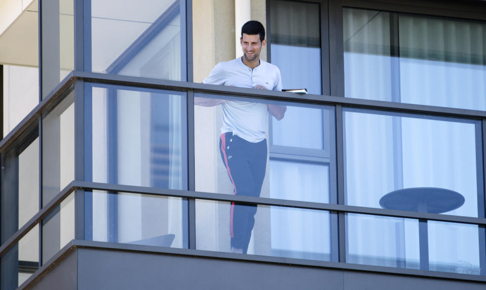 Novak Djokovic observa desde el balcón de su residencia en Adelaida, Australia, el martes 19 de enero de 2021. (Morgan Sette/AAP Image vía AP)