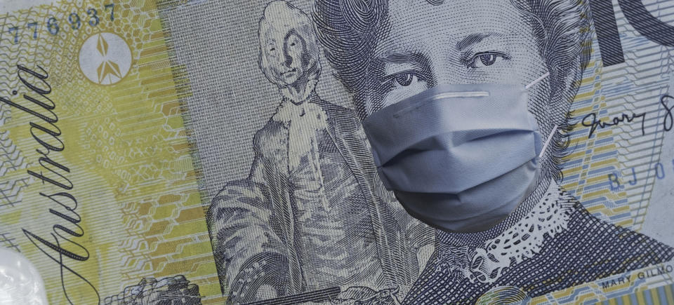 COVID-19 coronavirus in Australia, australian dollar money bill with face mask. COVID global stock market affection. World economy hit by corona virus outbreak. Financial crisis and coronavirus pandemic concept