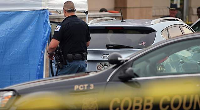 Cobb County police investigate an SUV where a toddler died after being stuck. Photo: AP