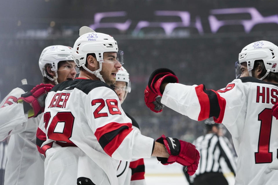 New Jersey Devils right wing Timo Meier, second from left, celebrates after his goal with defenseman John Marino, left, and center Nico Hischier, right, during the first period of an NHL hockey game against the Los Angeles Kings, Sunday, March 3, 2024, in Los Angeles. (AP Photo/Ryan Sun)
