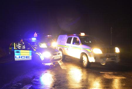 Emergency vehicles drive past a police road-block in the village of Cley in Norfolk, east England, January 8, 2014. REUTERS/Toby Melville