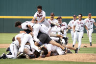 Virginia's Drew Hamrock, top, leaps on top of a dogpile with teammates after an NCAA college baseball tournament super regional game against Dallas Baptist, Monday, June 14, 2021, in Columbia, S.C. (AP Photo/Sean Rayford)