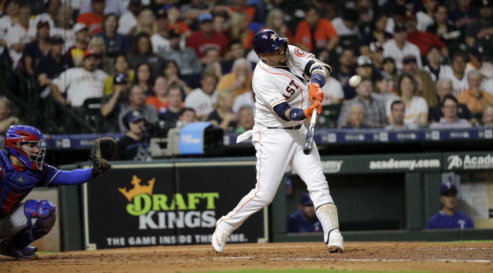 Houston Astros' Yuli Gurriel, right, hits a home run as Texas Rangers catcher Jose Trevino reaches for the pitch during the fifth inning of a baseball game Tuesday, Sept. 17, 2019, in Houston. (AP Photo/David J. Phillip)