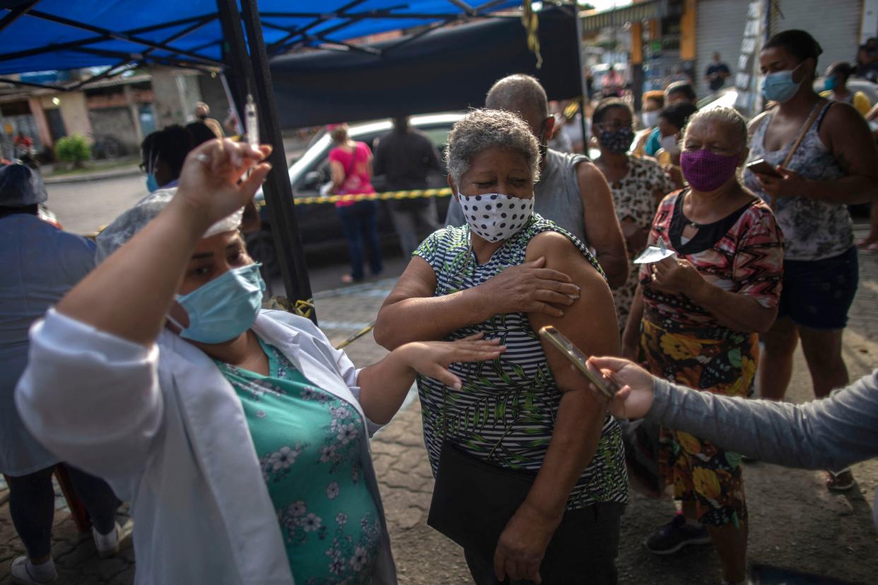 A woman is seen after receiving a dose of the COVID-19 vaccine at a vaccination center on Cangulo square, Saracuruna neighbourhood, in Duque de Caxias, Rio de Janeiro state, Brazil, on March 30, 2021. (Photo by Mauro Pimentel / AFP) (Photo by MAURO PIMENTEL/AFP via Getty Images)