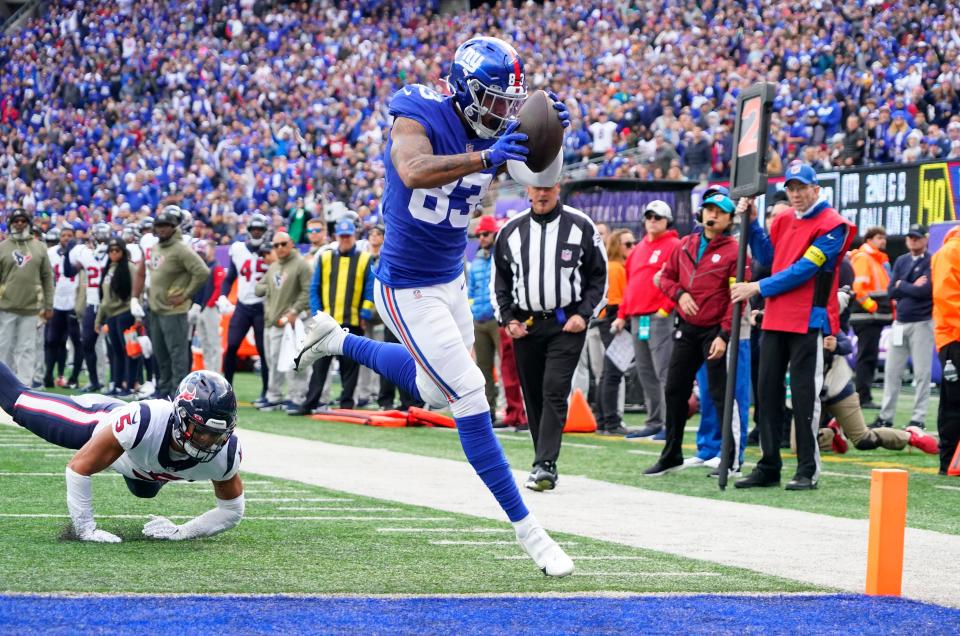 New York Giants tight end Lawrence Cager (83) scores a touchdown as Houston Texans safety Jalen Pitre (5) defends during the first quarter at MetLife Stadium.