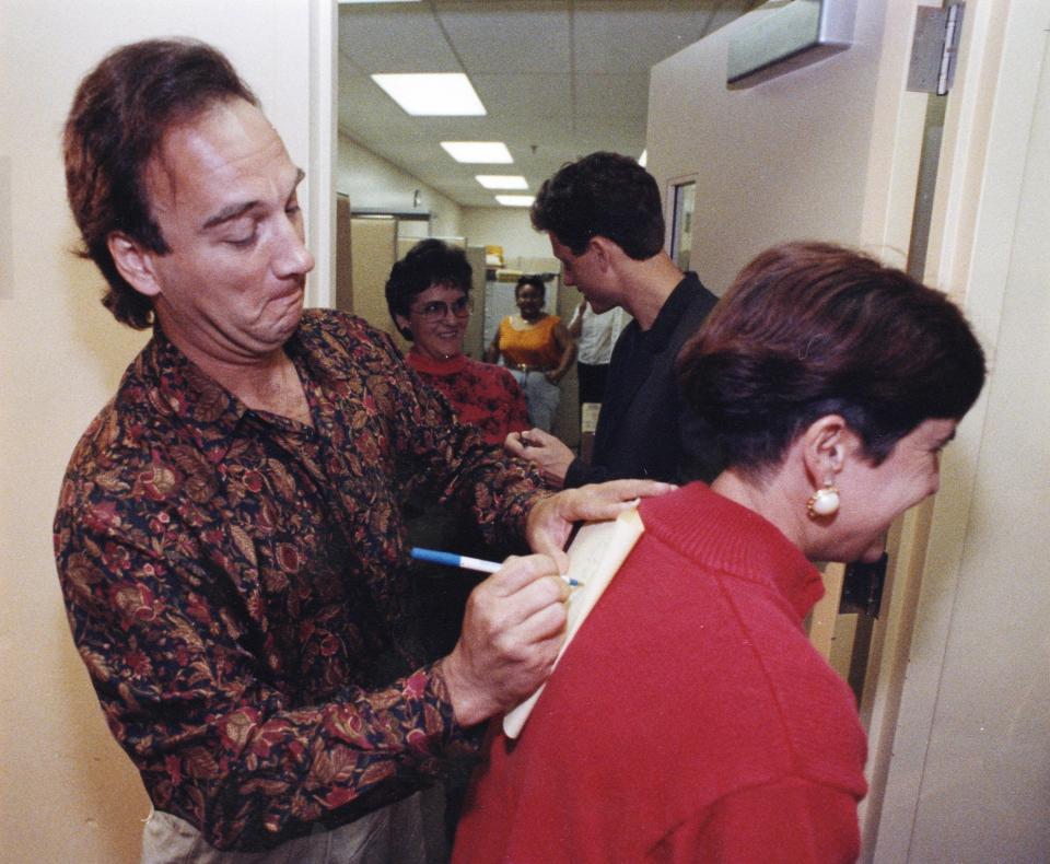 Actor James Belushi signs an autograph for Palm Beach County Sheriff's Office employee Sandy Ramirez (right) during a visit to Palm Beach County in October 1991 for the filming of "Traces of Red." Behind Belushi is co-star Tony Goldwyn. Parts of "Traces of Red" were filmed in Palm Beach.