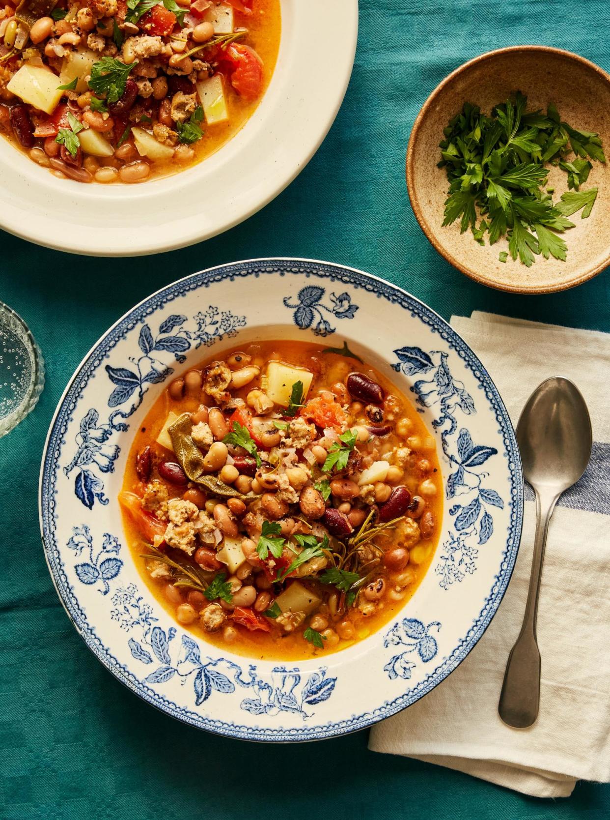 <span>Rachel Roddy’s bean stew with lots of herbs (and sausage, if you like).</span><span>Photograph: Matthew Hague/The Guardian. Food and prop styling: Lucy Turnbull. Food styling assistant: Katie Smith.</span>