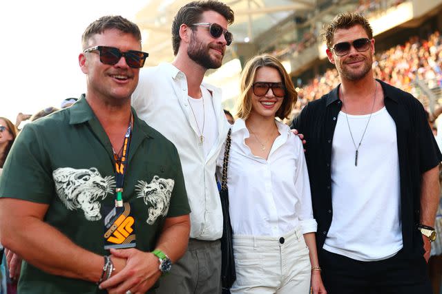 <p>Dan Istitene - Formula 1/Formula 1 via Getty</p> Luke Hemsworth, Liam Hemsworth, Gabriella Brooks and Chris Hemsworth pose for a photo on the grid prior to the F1 Grand Prix of Abu Dhabi at Yas Marina Circuit on November 26, 2023 in Abu Dhabi, United Arab Emirates